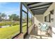 Relaxing screened porch with seating overlooking a scenic lawn and waterway at 7218 Cloister Dr # 7218, Sarasota, FL 34231