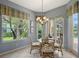 Cozy breakfast nook with a glass table, four chairs, and a large window offering views of the green outdoors at 7528 Ascot Ct, Bradenton, FL 34201