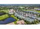 Aerial view showcasing the community pool, tennis courts, lake, and golf course at 7607 Grand Estuary Trl # 302, Bradenton, FL 34212