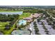 Community aerial view featuring a pool, lake, golf course, parking, and tennis courts at 7607 Grand Estuary Trl # 302, Bradenton, FL 34212