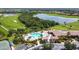 Scenic aerial view of community pool and clubhouse overlooking the golf course and lake at 7607 Grand Estuary Trl # 302, Bradenton, FL 34212