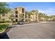 Exterior shot of condominium featuring covered parking, a beige facade, and well-maintained landscaping on a sunny day at 7607 Grand Estuary Trl # 302, Bradenton, FL 34212
