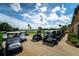 View of a row of golf carts on the golf course on a sunny day with the golf course visible in the background at 7607 Grand Estuary Trl # 302, Bradenton, FL 34212