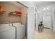 Bright laundry area with washer, dryer, shelving, and a pass-through to the entry hall at 7607 Grand Estuary Trl # 302, Bradenton, FL 34212