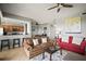 Bright living room with a partial view of the kitchen, a ceiling fan, and a combination of tile floors and neutral walls at 7607 Grand Estuary Trl # 302, Bradenton, FL 34212