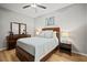 Bedroom features ceiling fan, wood floors, queen bed, ensuite bathroom, and dresser with mirror at 7607 Grand Estuary Trl # 302, Bradenton, FL 34212