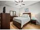 Bedroom features ceiling fan, wood floors, queen bed, ensuite bathroom, and dresser with mirror at 7607 Grand Estuary Trl # 302, Bradenton, FL 34212