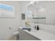 Bathroom with modern vanity, stone countertop, walk-in shower, and toilet at 8107 Slipway Dr, Sarasota, FL 34240