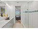 Well-lit bathroom featuring double vanity, a glass shower, and a view into the bedroom at 8107 Slipway Dr, Sarasota, FL 34240