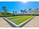 A well-maintained community bocce ball court, featuring vibrant green synthetic turf and landscaped surroundings at 8107 Slipway Dr, Sarasota, FL 34240
