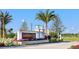 Welcoming entrance to the community, featuring lush landscaping, elegant signage, and a glimpse of the serene lake at 8107 Slipway Dr, Sarasota, FL 34240