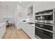 Modern kitchen featuring white cabinets, stainless steel appliances and range hood, quartz countertops and stylish backsplash at 8107 Slipway Dr, Sarasota, FL 34240