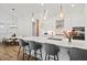 Modern kitchen features a large island, pendant lighting, white cabinetry, and stainless steel appliances at 8107 Slipway Dr, Sarasota, FL 34240