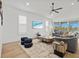 Bright, modern living room with a large sofa, decorative stools, and a view of the lake at 8107 Slipway Dr, Sarasota, FL 34240