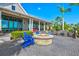Outdoor patio area with a stone fire pit, lounge seating, and views of the landscaped surroundings at 8107 Slipway Dr, Sarasota, FL 34240