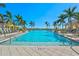 Stunning community pool featuring crystal-clear water and lush palm trees around the pool deck at 8107 Slipway Dr, Sarasota, FL 34240