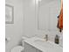 A clean half bathroom design featuring a modern mirror, a white sink with a gold faucet, and white walls at 8107 Slipway Dr, Sarasota, FL 34240