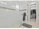 A walk-in shower features white tile walls with accent border, glass door, and tile floor at 8107 Slipway Dr, Sarasota, FL 34240