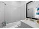 Bathroom featuring gray tile walls, a shower/tub combination and a large black framed mirror at 845 Burlington N Ave, St Petersburg, FL 33701
