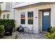 Inviting front porch with stone pavers, a blue door, and a cozy outdoor seating area at 845 Burlington N Ave, St Petersburg, FL 33701