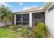 Back exterior showcasing the well-maintained yard, landscaping and screened in patio at 10008 Sugar Mill Dr, Bradenton, FL 34212