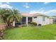 Exterior shot of the back of the house, green lawn, and screened in patio at 10008 Sugar Mill Dr, Bradenton, FL 34212