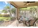 Screened-in patio with dining table, chairs, and views of the lush backyard at 10008 Sugar Mill Dr, Bradenton, FL 34212