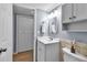 Bathroom boasts a white vanity with storage, framed mirror, and beige tile accent at 10415 Waterbird Way # 10415, Bradenton, FL 34209