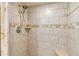 Close up of the tiled shower featuring seashell decor in earth tones at 10415 Waterbird Way # 10415, Bradenton, FL 34209