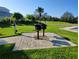 Outdoor community grill area on a stone patio with green grass and palm trees at 1264 Riverscape St # B, Bradenton, FL 34208