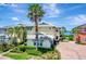 Two-story home featuring bright yellow paint, gray shingles, a driveway, and well-maintained landscaping at 1264 Riverscape St # B, Bradenton, FL 34208