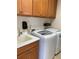 Laundry room featuring a utility sink, washer, dryer, and wooden cabinets at 1264 Riverscape St # B, Bradenton, FL 34208