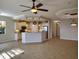 Open-concept living room with tile flooring, ceiling fan, and view into the kitchen with granite countertops at 1264 Riverscape St # B, Bradenton, FL 34208