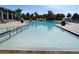 Large community pool with a ramp entry is surrounded by lush landscaping and lounge chairs at 1264 Riverscape St # B, Bradenton, FL 34208
