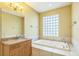 Bathroom with granite vanity, soaking tub, and decorative glass block window at 1330 16Th St, Sarasota, FL 34236