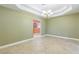 Elegant dining room with tray ceilings, chandelier, and neutral tile flooring, adjacent to the kitchen at 1330 16Th St, Sarasota, FL 34236