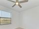 Well-lit bedroom with a ceiling fan and large window overlooking the neighborhood at 15507 Sunny Day Dr, Bradenton, FL 34211