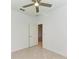 A clean, tiled bedroom features a ceiling fan and an open doorway to an adjoining room at 15507 Sunny Day Dr, Bradenton, FL 34211