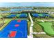 Aerial view of community basketball and tennis courts with lush landscaping and picturesque lake backdrop at 15507 Sunny Day Dr, Bradenton, FL 34211