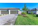 New construction home with two-car garage, beautiful landscaping, and a paver driveway at 15507 Sunny Day Dr, Bradenton, FL 34211