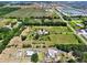 Aerial view of property featuring a large lot with verdant fields, mature trees, and a long driveway at 16305 E State Road 64, Bradenton, FL 34212