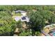 Aerial view of a home featuring solar panels, lush landscaping and mature trees at 1631 Madison Ave, North Port, FL 34286
