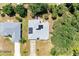 Aerial shot reveals a roof adorned with solar panels, surrounded by mature trees at 1631 Madison Ave, North Port, FL 34286