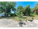 Serene backyard with lush greenery, mature trees, and a brick patio for entertaining at 1631 Madison Ave, North Port, FL 34286