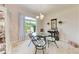 Elegant dining room with glass-top table, chandelier, and natural light from large window at 1631 Madison Ave, North Port, FL 34286