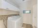 Well-organized laundry room with washer, dryer, and ample storage cabinets above at 1631 Madison Ave, North Port, FL 34286