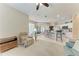 Open-concept living area with beige carpet flooring and kitchen access, perfect for modern living at 1631 Madison Ave, North Port, FL 34286