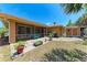 Covered patio with lush landscaping, brick pavers, seating, and an adjacent storage shed at 1631 Madison Ave, North Port, FL 34286