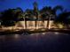 Beautiful backyard featuring uplighting, highlighting manicured landscaping and brick patio at 1719 Kenilworth St, Sarasota, FL 34231