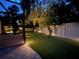 Expansive backyard with lush lawn, brick patio, and uplighting for serene evenings at 1719 Kenilworth St, Sarasota, FL 34231